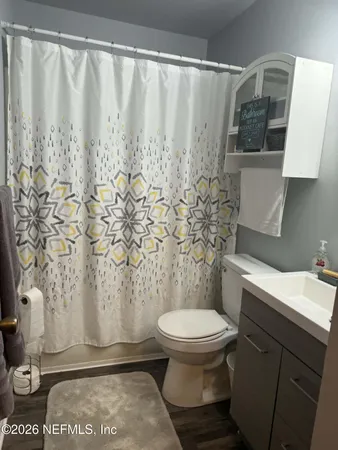 a bathroom with a toilet and a shower curtain