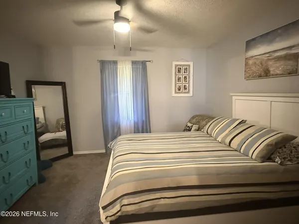 a bedroom with a bed and a mirror