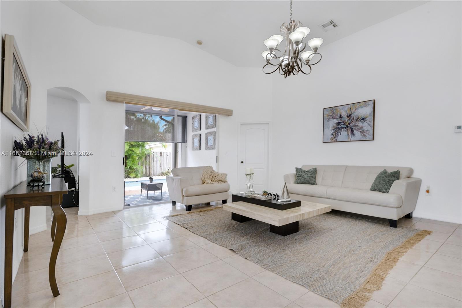 6850 Southwest 159th Place Miami, FL 33193 - Photo 2 of 18 a living room with furniture and a chandelier