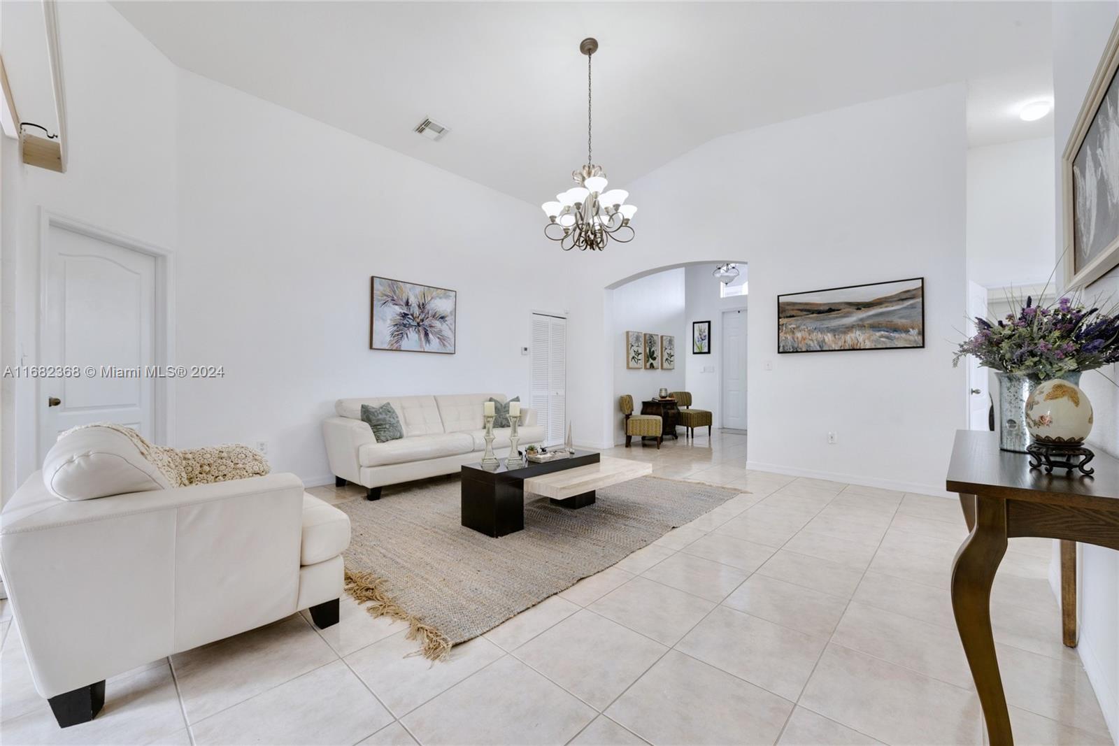 6850 Southwest 159th Place Miami, FL 33193 - Photo 3 of 18 a living room with furniture and a chandelier