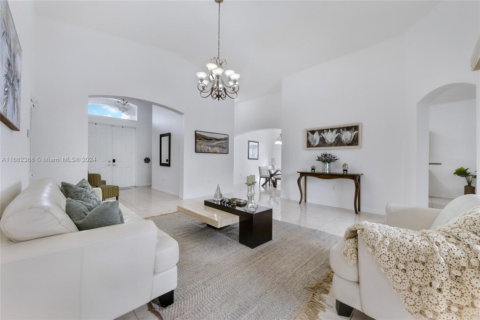 6850 Southwest 159th Place Miami, FL 33193 - Photo 4 of 18 a living room with furniture a chandelier and a flat screen tv
