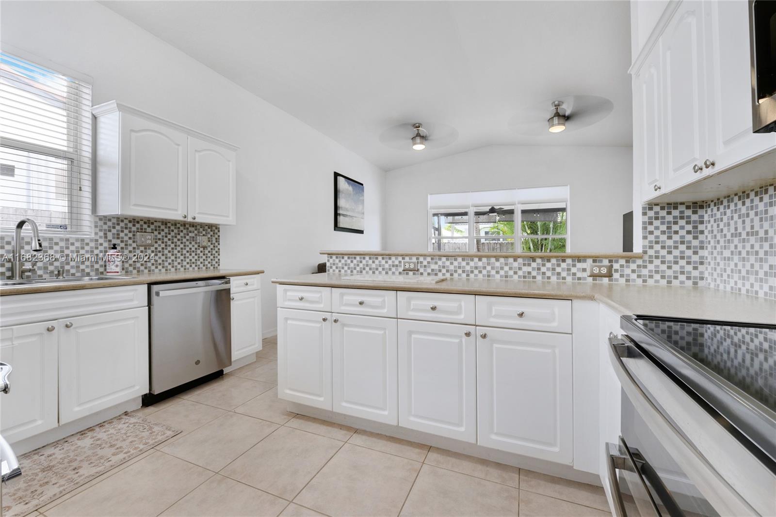 6850 Southwest 159th Place Miami, FL 33193 - Photo 7 of 18 a kitchen with granite countertop white cabinets and white appliances