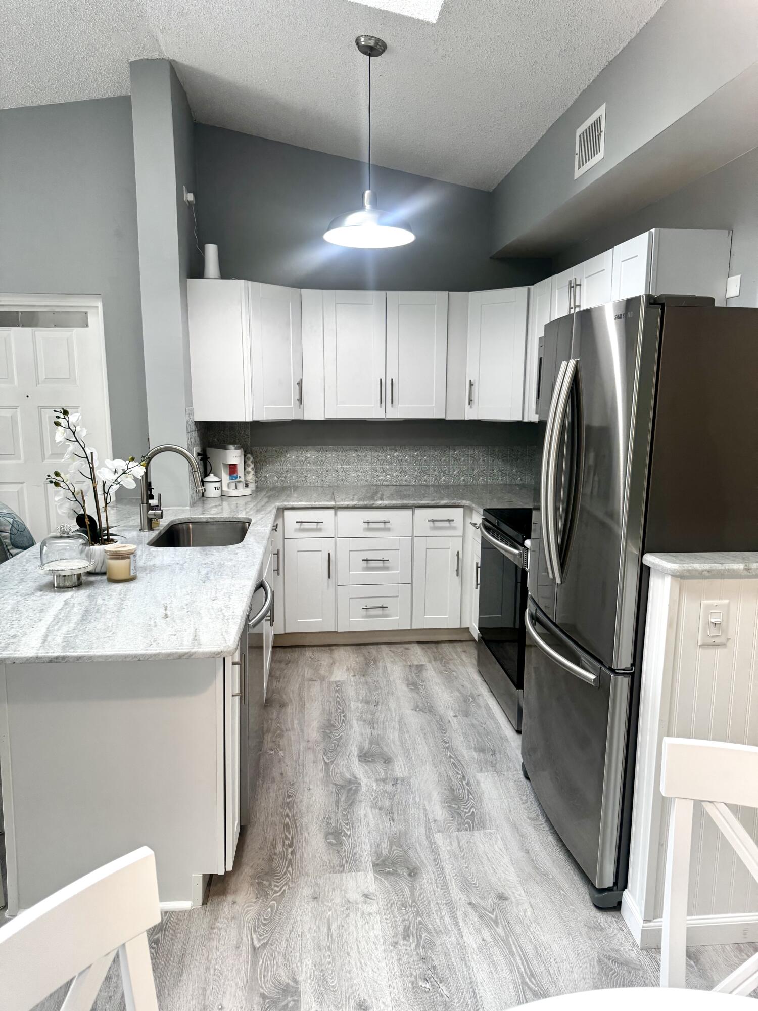 2502 Southeast Anchorage Cove, Unit G3 Port St. Lucie, FL 34952 - Photo 11 of 22 a kitchen with granite countertop a refrigerator a sink a stove a microwave and island