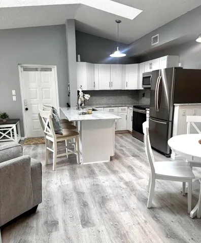 a kitchen with a dining table chairs and a refrigerator