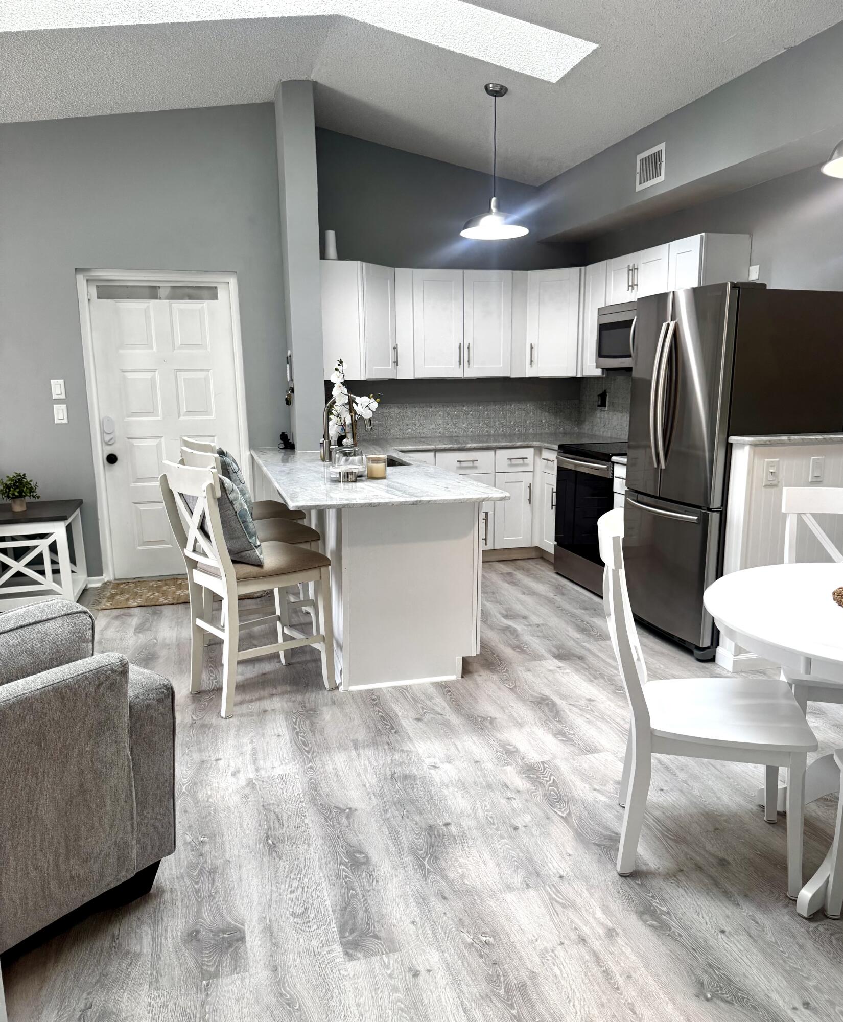 2502 Southeast Anchorage Cove, Unit G3 Port St. Lucie, FL 34952 - Photo 12 of 22 a kitchen with a dining table chairs and a refrigerator
