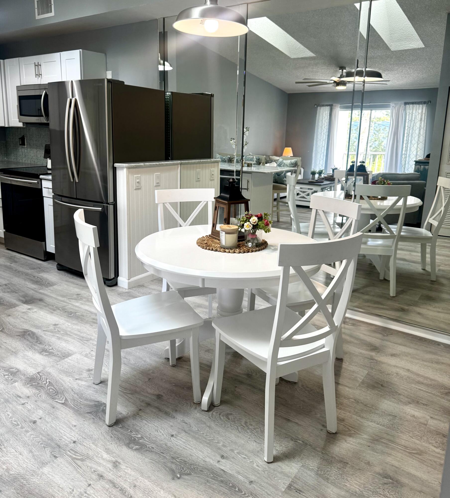 2502 Southeast Anchorage Cove, Unit G3 Port St. Lucie, FL 34952 - Photo 13 of 22 a dining room with stainless steel appliances kitchen island granite countertop a dining table chairs and a refrigerator