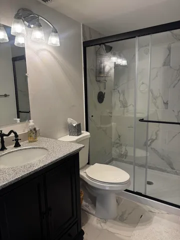 a bathroom with a sink toilet and shower