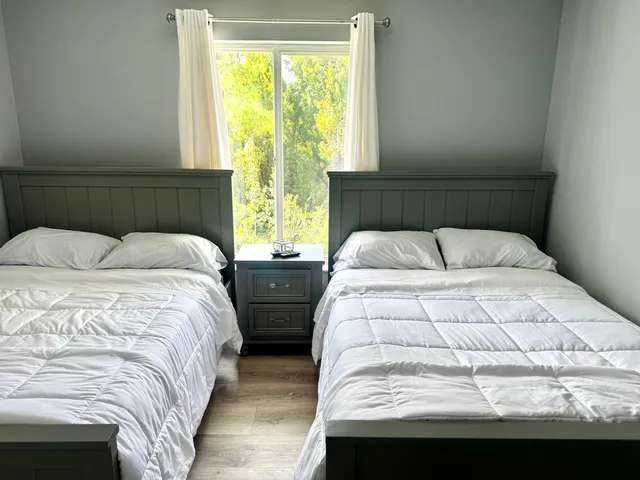 a bedroom with two beds and a window