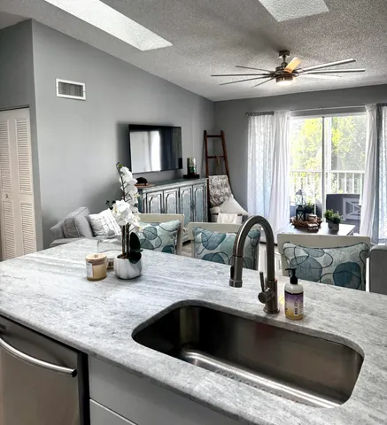 a kitchen with sink a faucet and chairs