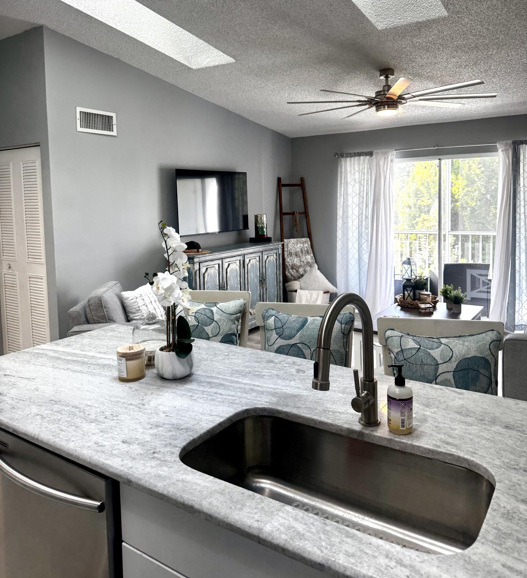 2502 Southeast Anchorage Cove, Unit G3 Port St. Lucie, FL 34952 - Photo 9 of 22 a kitchen with sink a faucet and chairs