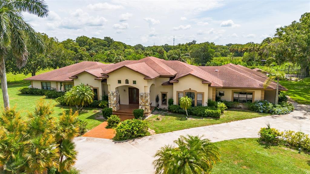 a view of house with garden and tall tress