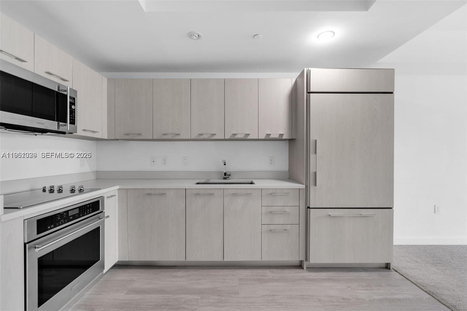 45 Southwest 9th Street, Unit 2204 Miami, FL 33130 - Photo 7 of 23 a kitchen with stainless steel appliances white cabinets and a refrigerator