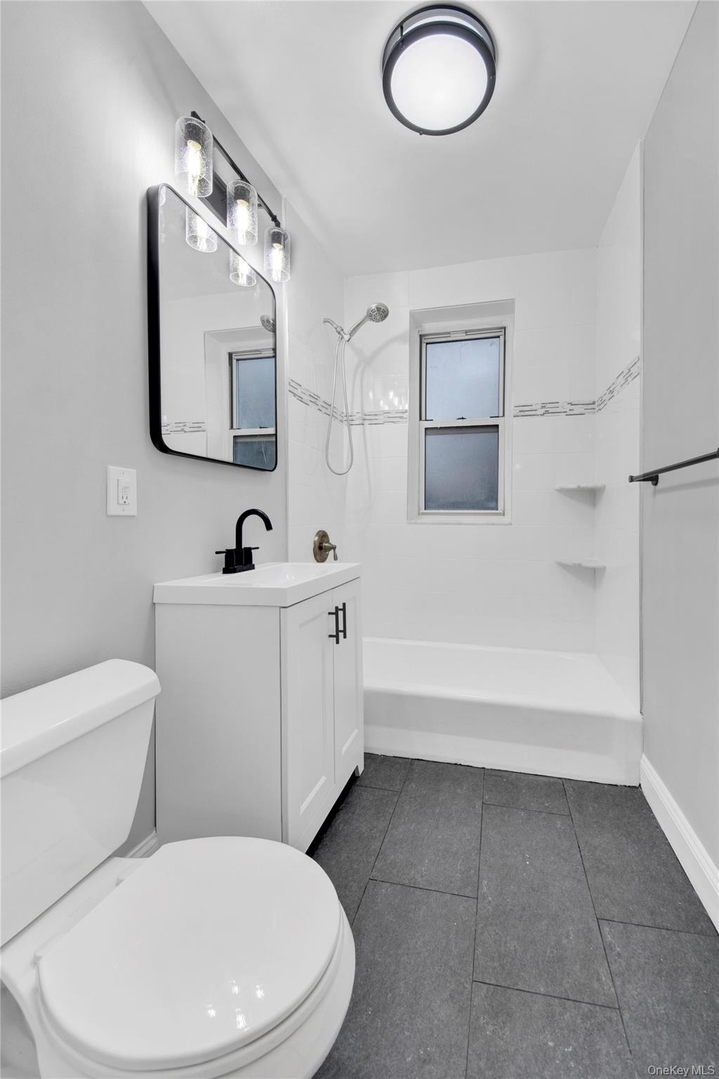 1 Vincent Road, Unit 2N Yonkers, NY 10708 - Photo 15 of 19 a white toilet sitting next to a bathroom sink and tub