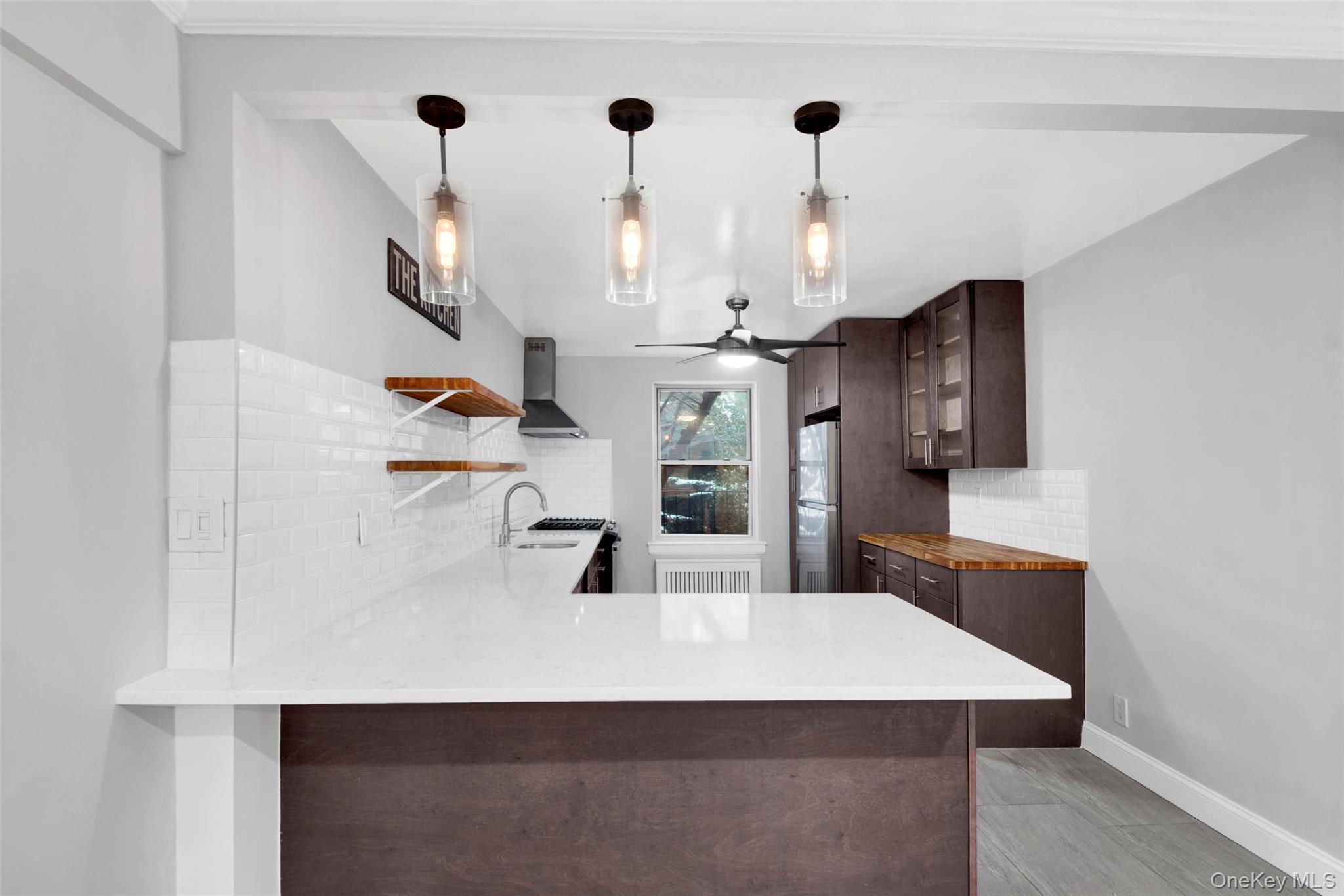 1 Vincent Road, Unit 2N Yonkers, NY 10708 - Photo 2 of 19 a kitchen with kitchen island white cabinets and refrigerator
