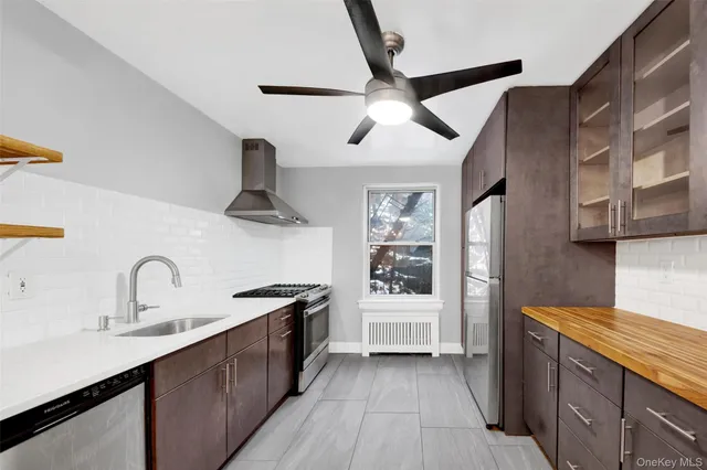 a kitchen with stainless steel appliances kitchen island granite countertop a refrigerator and a sink