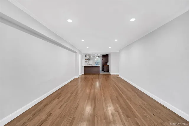 an empty room with wooden floor and window