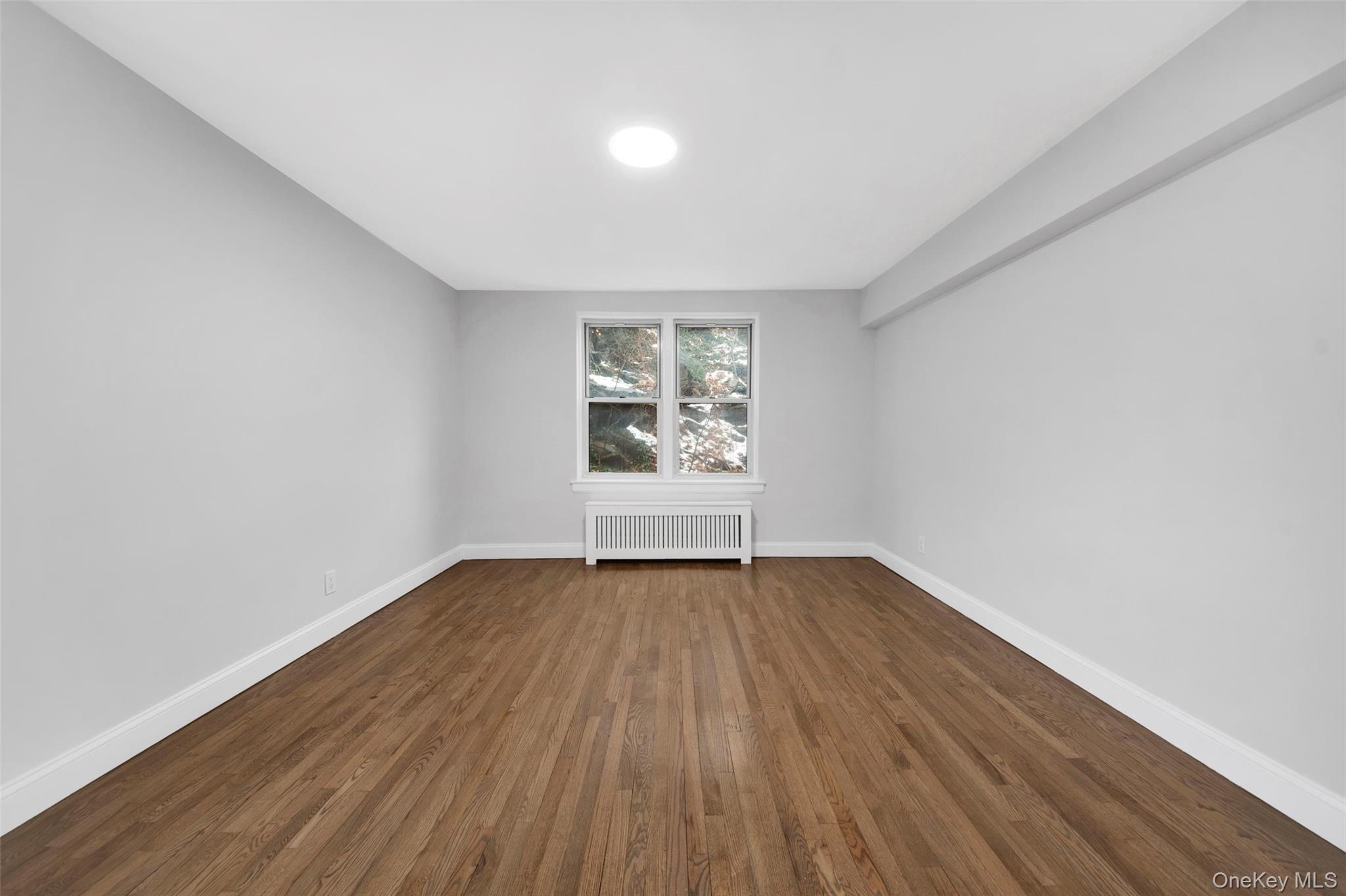 1 Vincent Road, Unit 2N Yonkers, NY 10708 - Photo 10 of 19 an empty room with wooden floor and window