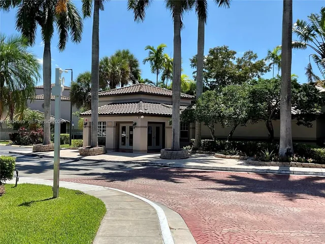 a front view of a building with palm trees