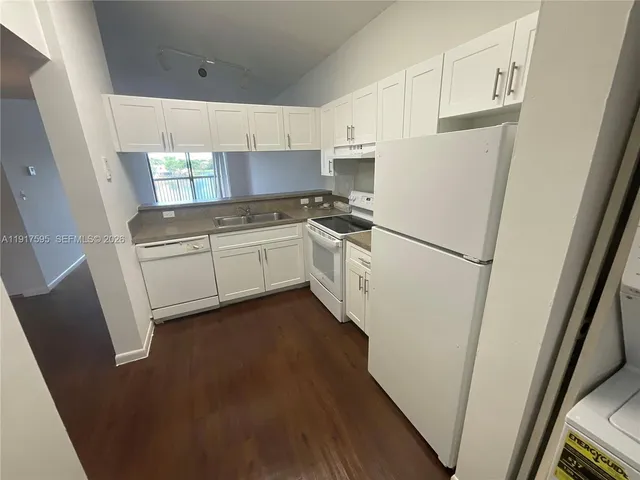 a kitchen with white cabinets and white appliances