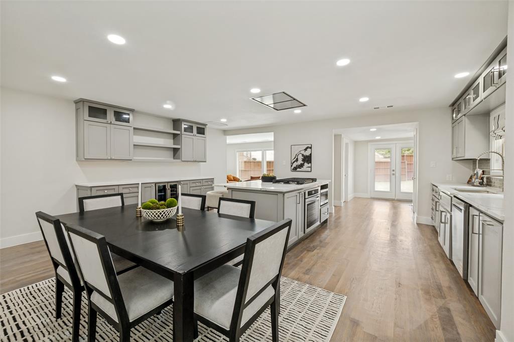 2006 Marydale Road Dallas, TX 75208 - Photo 19 of 40 Open-concept kitchen and dining area featuring light wood-finish flooring, a central island with integrated appliances, light gray cabinetry, and white countertops