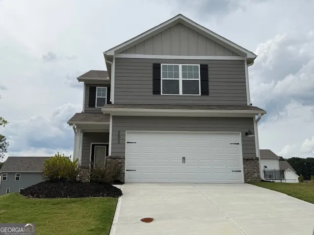 a front view of a house with a yard and garage