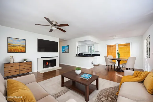 a living room with furniture a flat screen tv and a fireplace