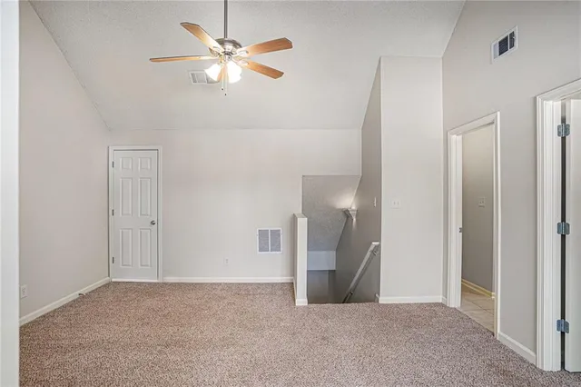 a view of an empty room with a ceiling fan