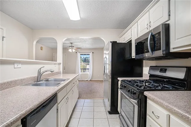 a kitchen with stainless steel appliances granite countertop a sink stove and cabinets