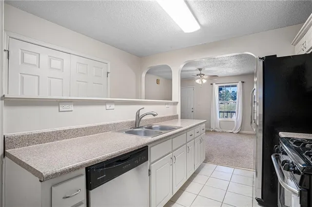 a kitchen with a sink dishwasher and a stove with wooden floor