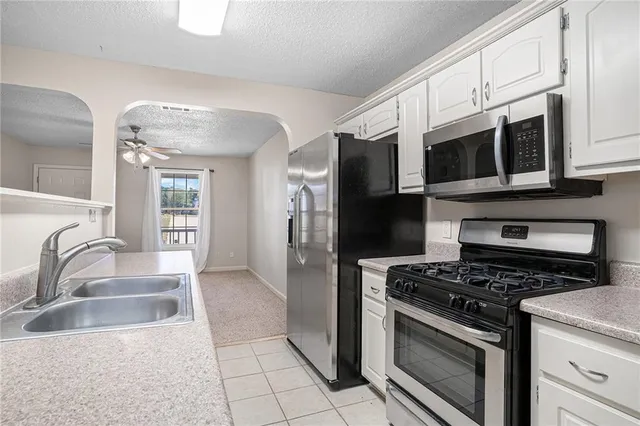 a kitchen with stainless steel appliances granite countertop a stove microwave and refrigerator