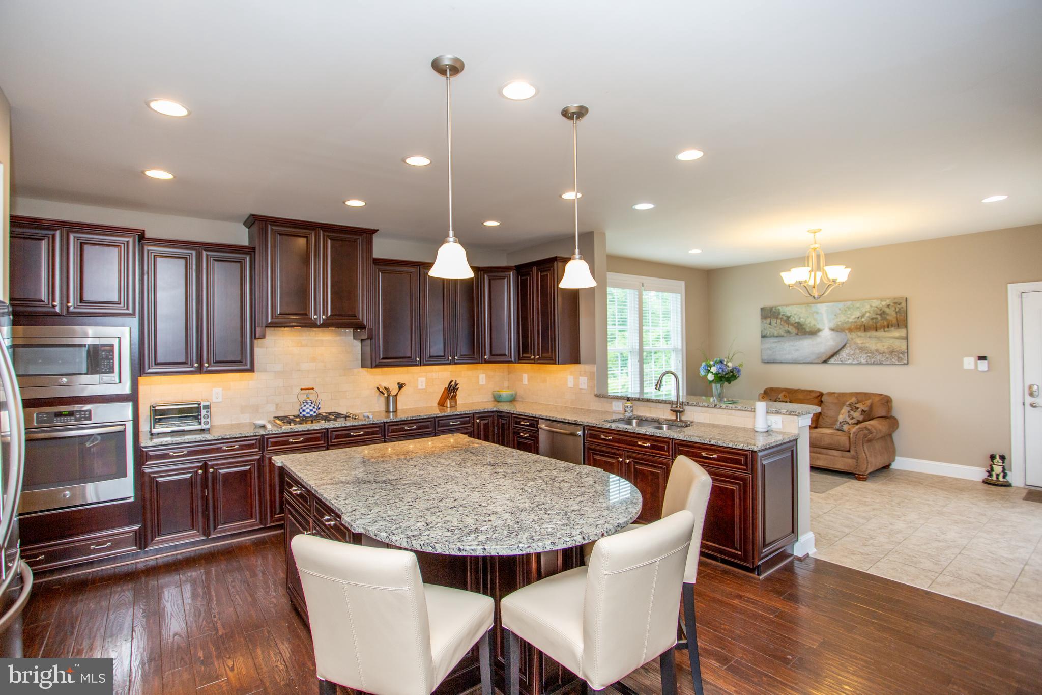 4682 Plough Tavern Road Doylestown, PA 18902 - Photo 12 of 42 a kitchen with stainless steel appliances granite countertop a kitchen island hardwood floor sink stove dining table and chairs