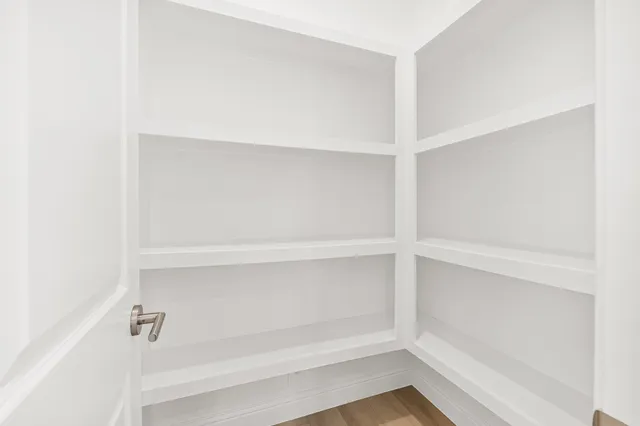 a view of a big room with windows and chandelier fan