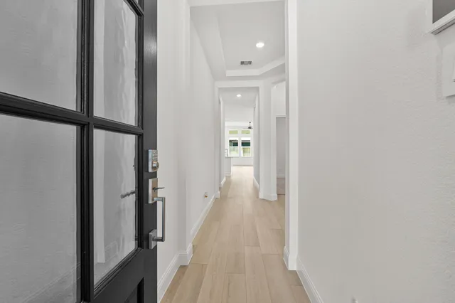 a view of a hallway with wooden floor