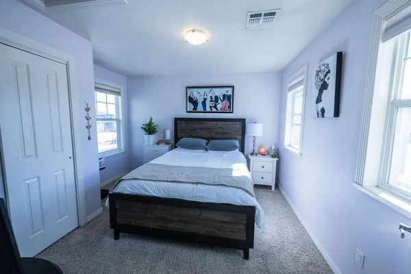 a spacious bedroom with a bed and a window