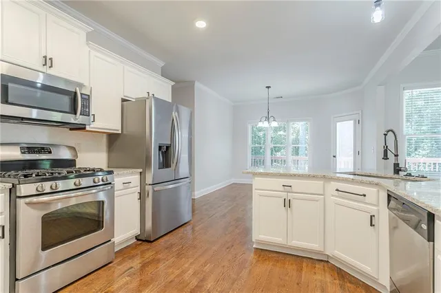 a kitchen with stainless steel appliances a stove a sink and a microwave