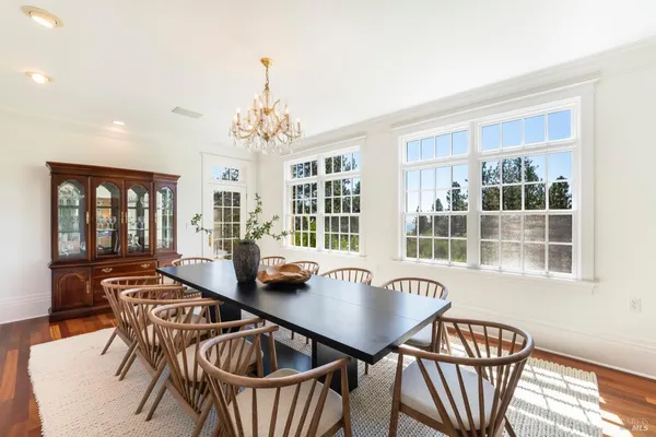 a dining room with furniture a chandelier and wooden floor