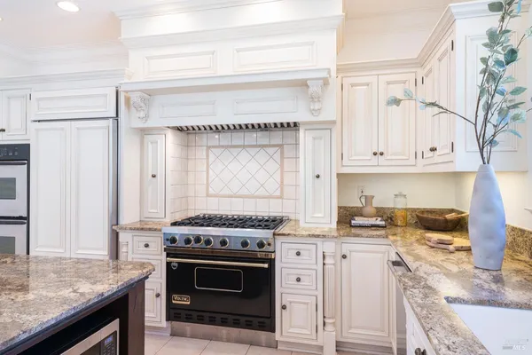 a kitchen with granite countertop a stove sink and cabinets