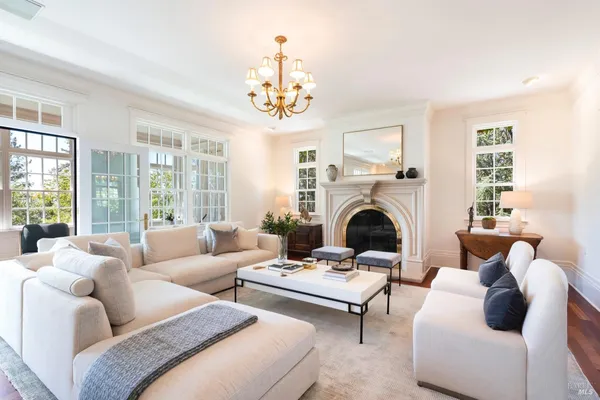 a living room with furniture a fireplace and a chandelier