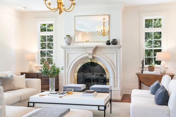 a living room with furniture a large window and a fireplace