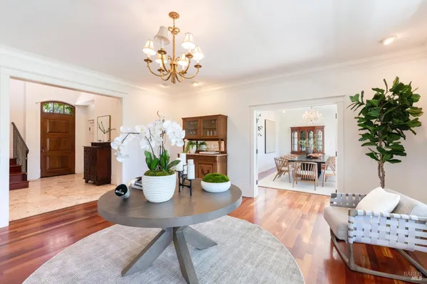 a view of a dining room with furniture a chandelier and wooden floor
