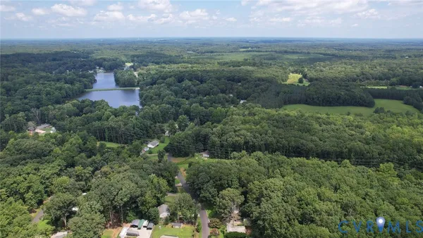 an aerial view of residential house with outdoor space and trees all around