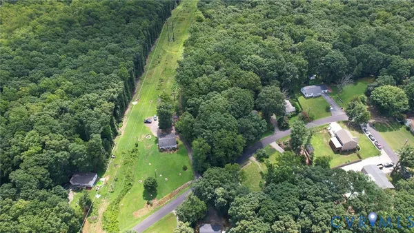 an aerial view of residential houses with outdoor space and trees