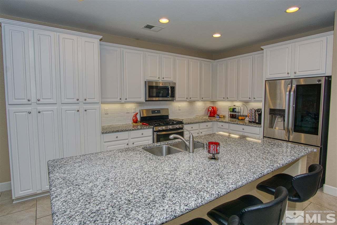 1820 Cascade Stable Lane Reno, NV 89521 - Photo 3 of 17 a kitchen with granite countertop stainless steel appliances a stove refrigerator sink and cabinets