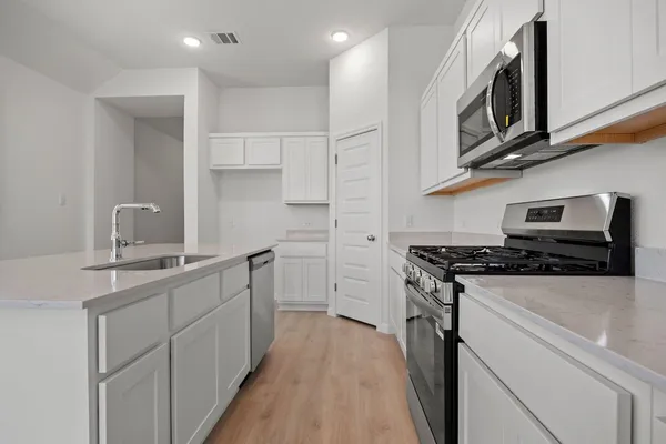 a kitchen with stainless steel appliances a sink stove and cabinets