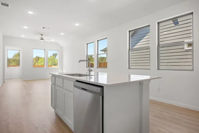 a kitchen with stainless steel appliances granite countertop a sink and wooden cabinets