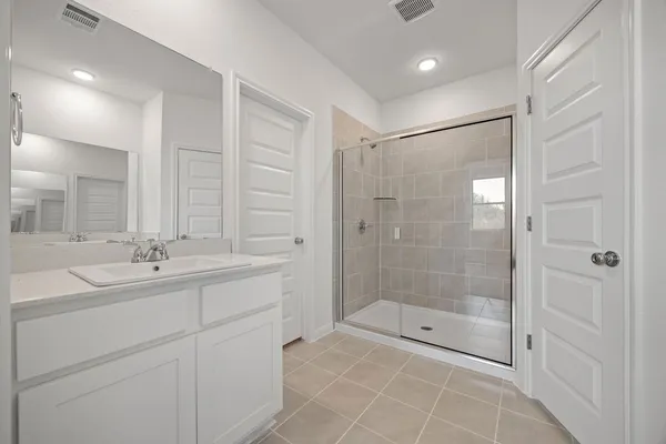 a bathroom with a shower sink and mirror