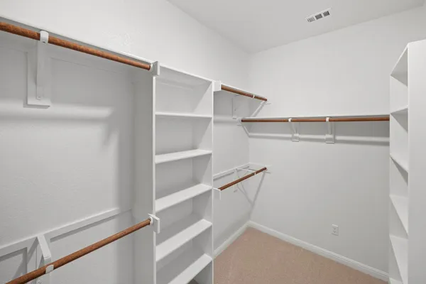 a view of walk in closet with empty racks