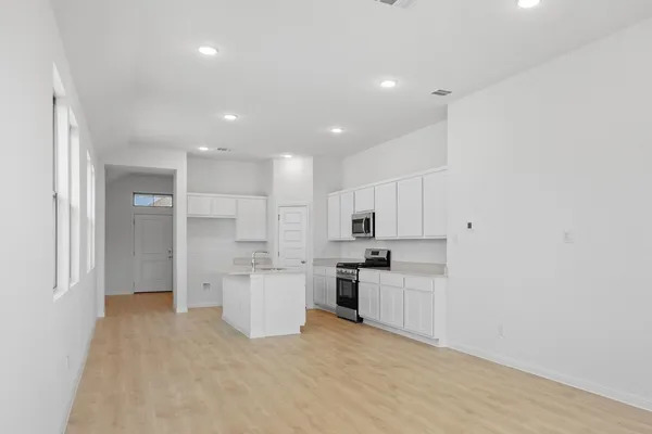 a kitchen with white cabinets and stainless steel appliances