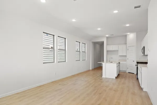 a view of empty room with wooden floor and window