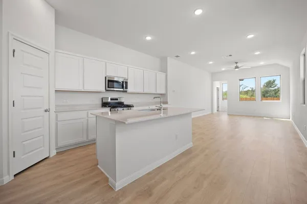 a kitchen with a refrigerator and a stove top oven